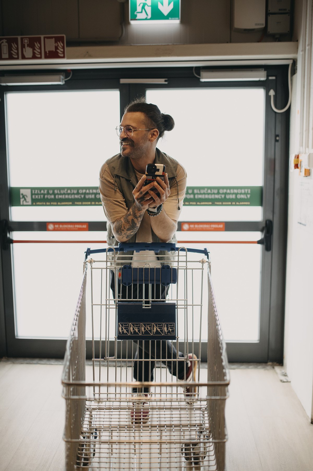 Persona revisando gastos con el teléfono mientras hace compras